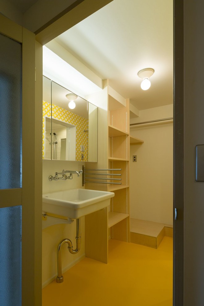 Cette image montre un petit WC et toilettes minimaliste avec un placard sans porte, WC séparés, un mur blanc, un sol en vinyl, un lavabo suspendu, un sol jaune, meuble-lavabo suspendu, un plafond en papier peint et du papier peint.
