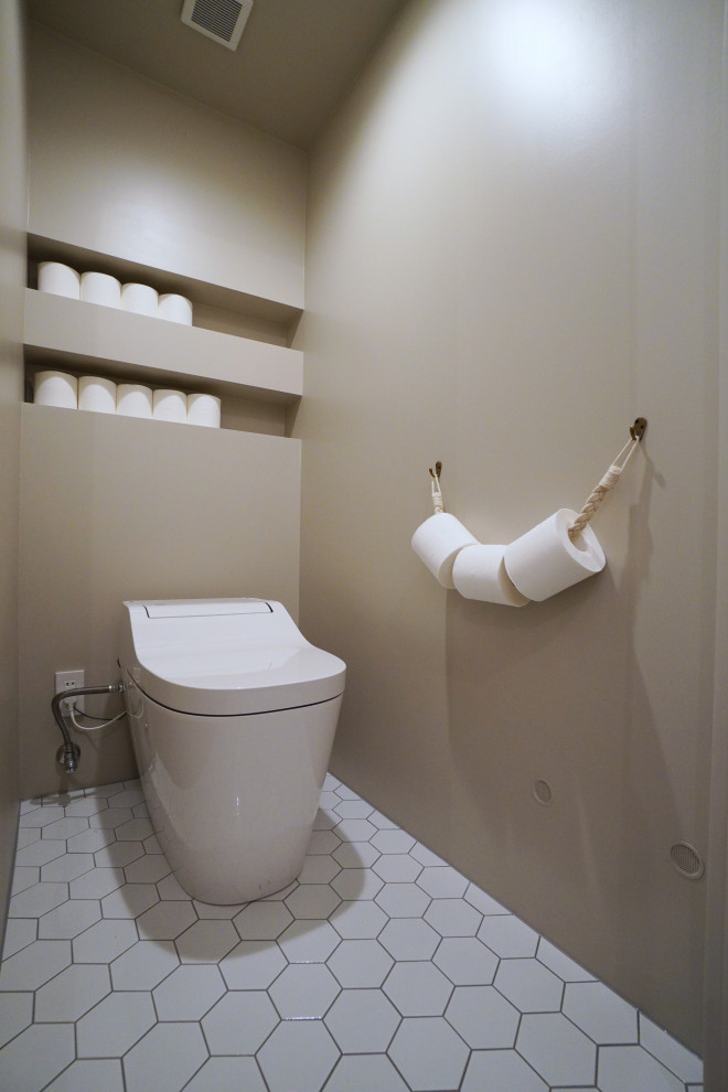 東京23区にあるモダンスタイルのおしゃれなトイレ・洗面所 (オープンシェルフ、ベージュのキャビネット、一体型トイレ	、ベージュの壁、磁器タイルの床、白い床) の写真