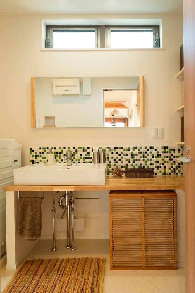 Aménagement d'un WC et toilettes campagne en bois brun avec un placard à porte persienne, un mur blanc, une vasque, un plan de toilette en bois, un sol beige et un plan de toilette marron.