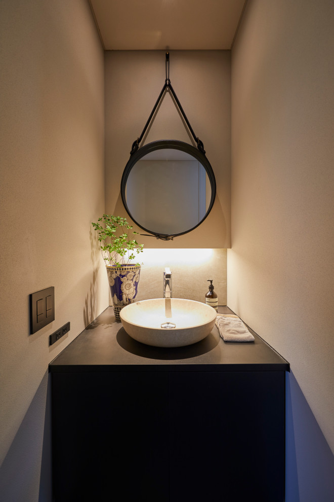 Inspiration for a contemporary cloakroom in Other with black cabinets, white tiles, black worktops, beige walls, beaded cabinets, a vessel sink and a built in vanity unit.
