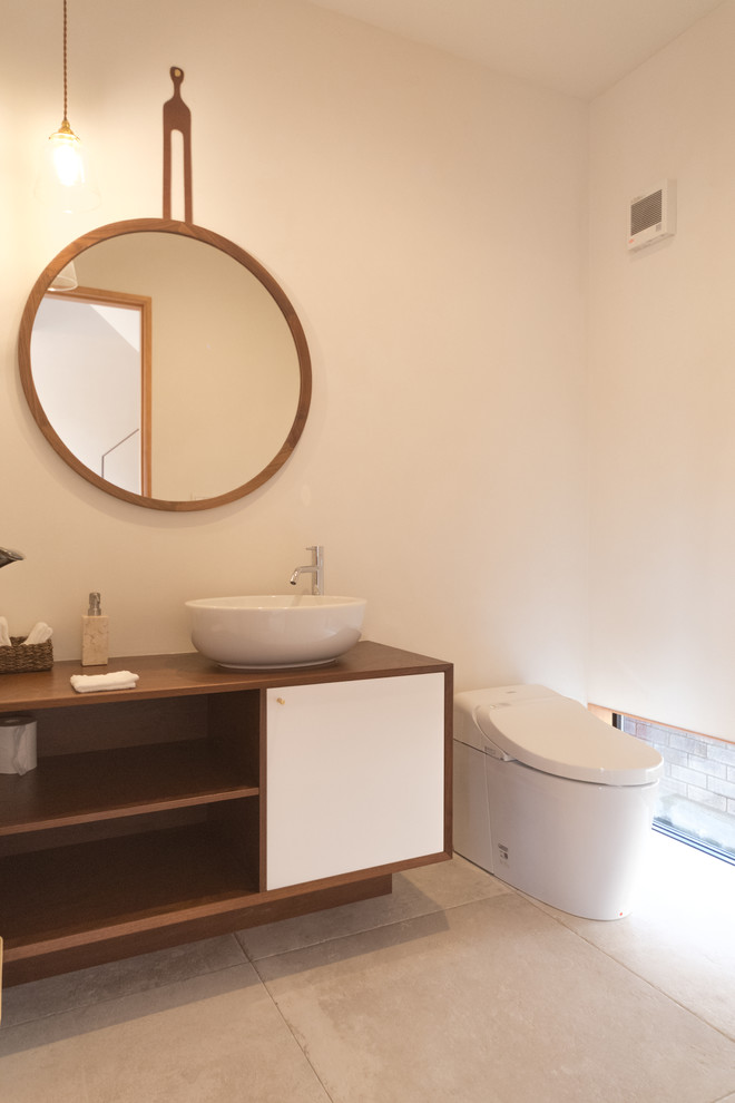Idéer för att renovera ett orientaliskt toalett, med släta luckor, vita skåp, vita väggar, ett fristående handfat, träbänkskiva och beiget golv