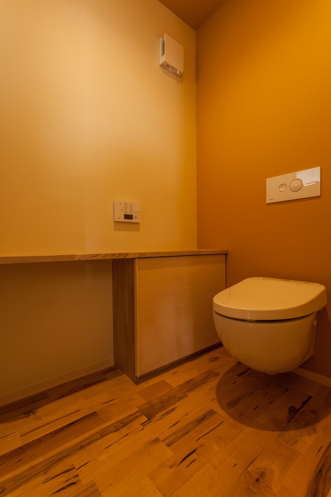 Стильный дизайн: маленький туалет в стиле модернизм с инсталляцией, белыми стенами, паркетным полом среднего тона и столешницей из дерева для на участке и в саду - последний тренд