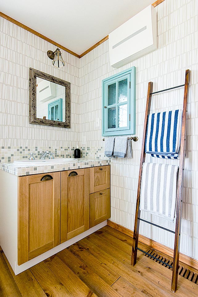 Idéer för rustika toaletter, med vita väggar, mellanmörkt trägolv, ett nedsänkt handfat, kaklad bänkskiva, luckor med infälld panel och skåp i ljust trä