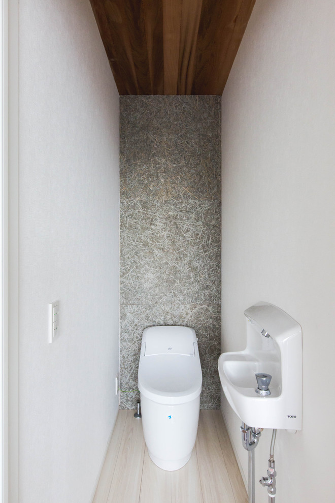 Ejemplo de aseo moderno pequeño con bidé, paredes grises, suelo de contrachapado, lavabo tipo consola y suelo beige