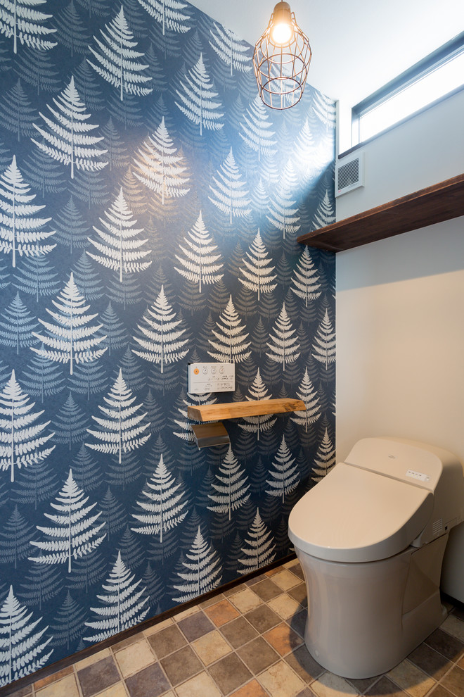 Cette photo montre un WC et toilettes scandinave avec un sol marron et WC à poser.