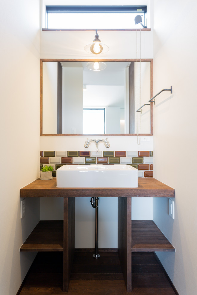 Kleine Asiatische Gästetoilette mit offenen Schränken, weißer Wandfarbe, dunklem Holzboden, Waschtisch aus Holz, braunem Boden und brauner Waschtischplatte in Sonstige