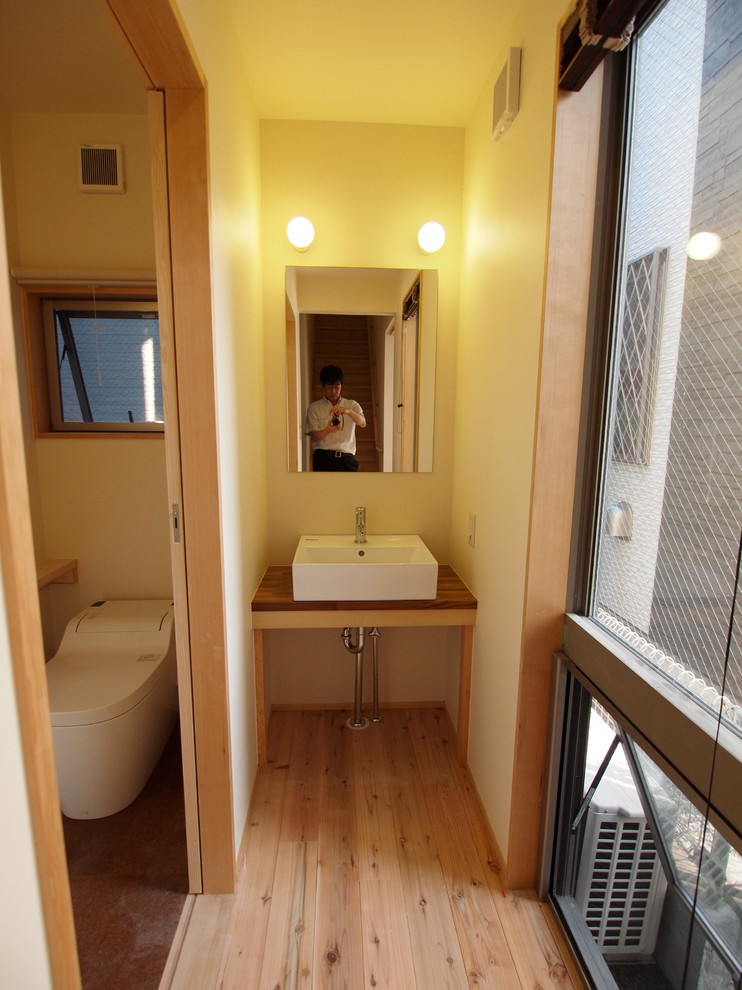 東京23区にある小さなトランジショナルスタイルのおしゃれなトイレ・洗面所 (ベージュの壁、ベッセル式洗面器、木製洗面台) の写真