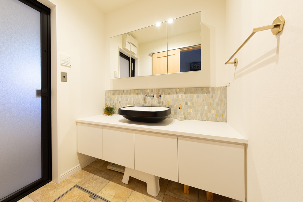 Example of a minimalist stone tile powder room design in Other with white walls and a drop-in sink