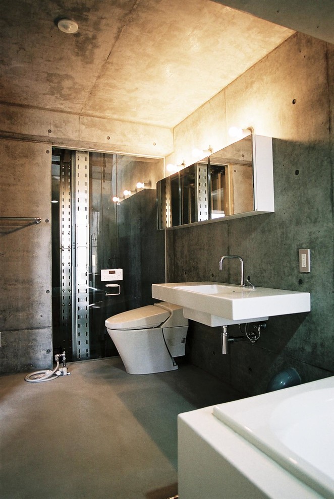 Moderne Gästetoilette mit grauer Wandfarbe, Wandwaschbecken und grauem Boden in Tokio Peripherie