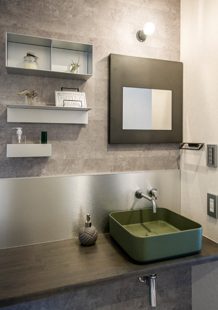 Moderne Gästetoilette mit grüner Wandfarbe und Aufsatzwaschbecken in Sonstige