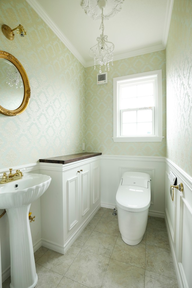 Стильный дизайн: туалет в викторианском стиле с фасадами с утопленной филенкой, белыми фасадами, зелеными стенами, консольной раковиной и серым полом - последний тренд