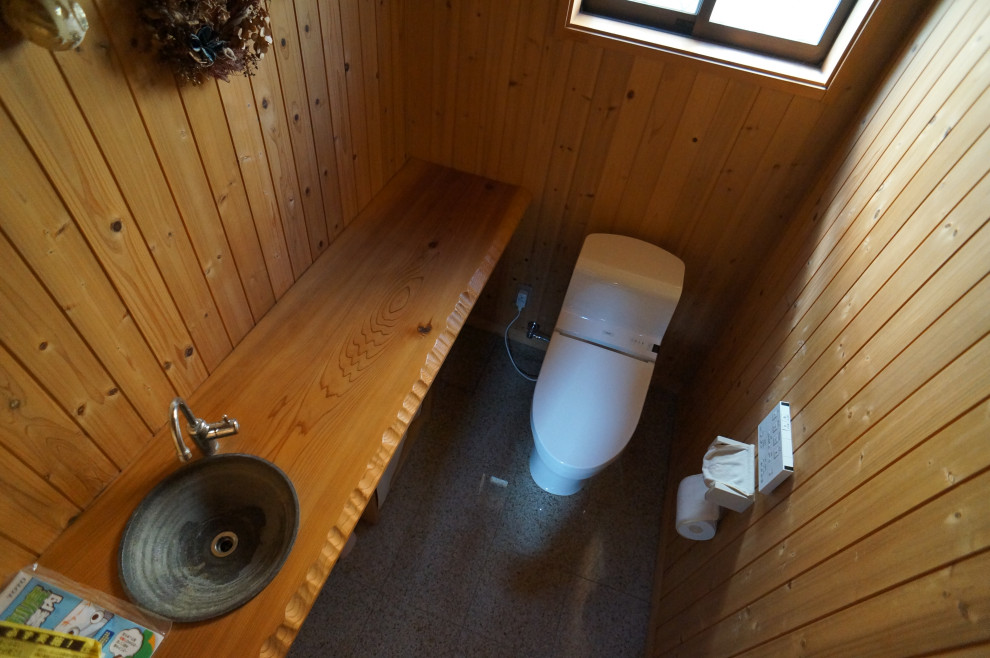 他の地域にある低価格の広いトラディショナルスタイルのおしゃれなトイレ・洗面所 (一体型トイレ	、茶色い壁、ピンクの床) の写真