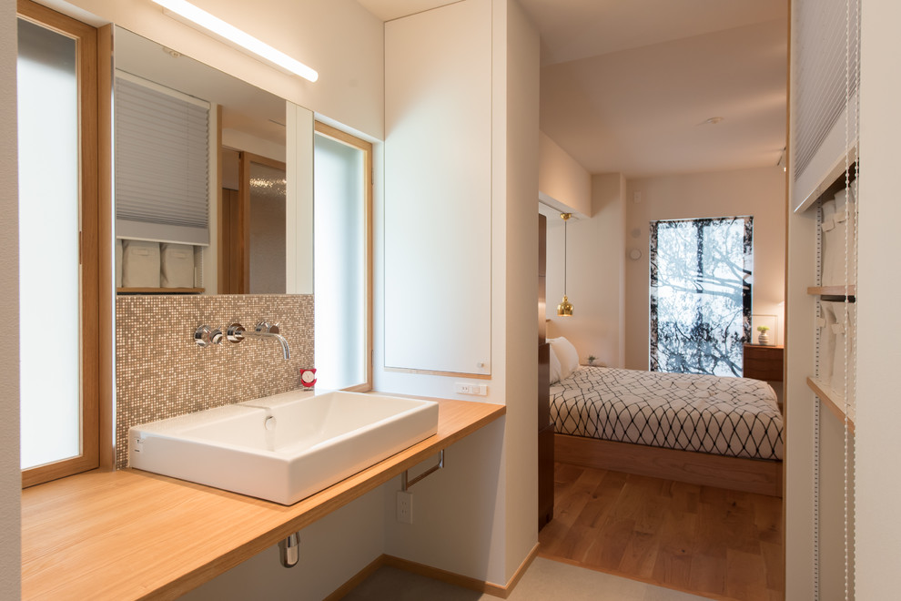 Cette photo montre un WC et toilettes moderne avec un lavabo posé, un plan de toilette en bois et un sol gris.