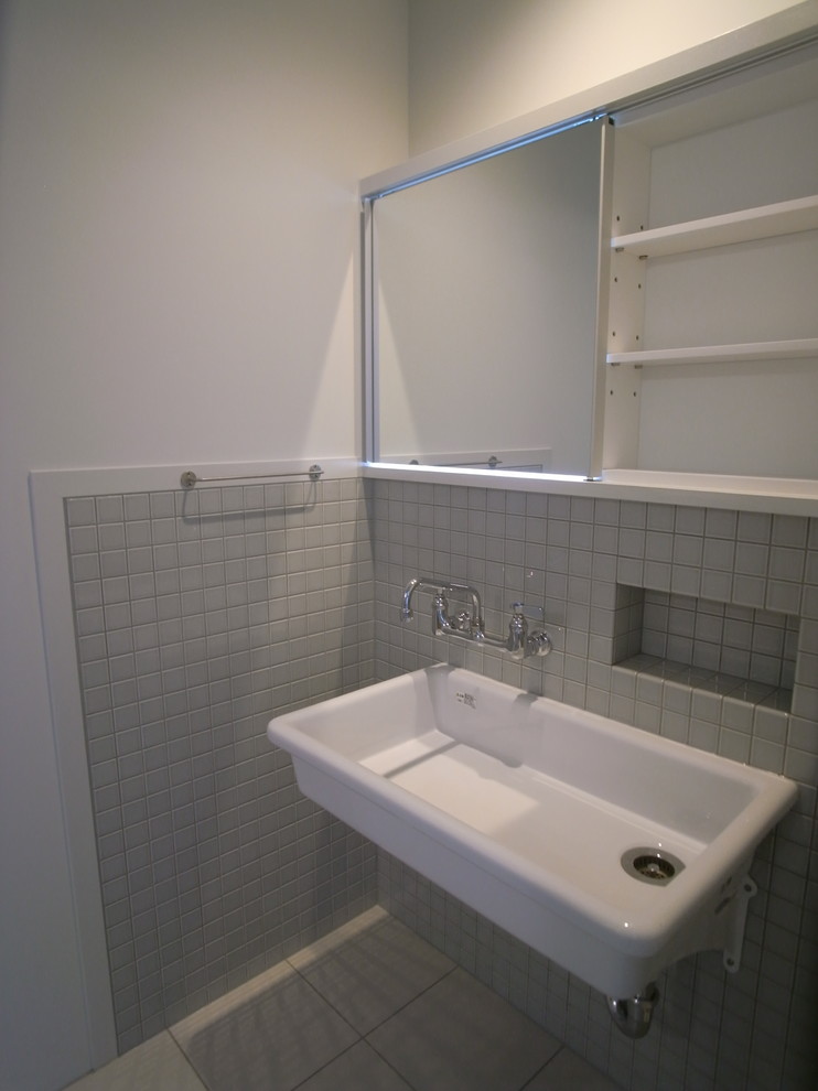 Источник вдохновения для домашнего уюта: туалет в восточном стиле с серой плиткой, керамической плиткой, серыми стенами, полом из керамической плитки, подвесной раковиной, бежевым полом и белой столешницей