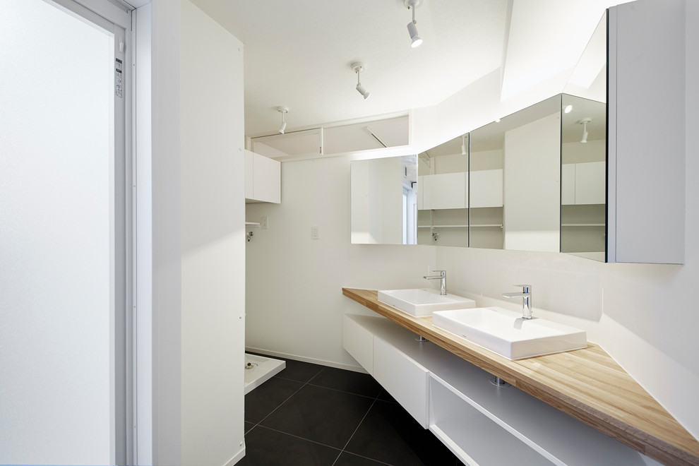 Idee per un bagno di servizio minimalista di medie dimensioni con ante bianche, pareti bianche, pavimento in gres porcellanato, top in legno, pavimento nero e top marrone