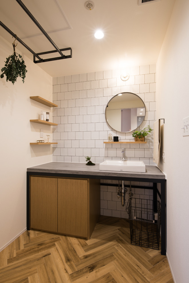 札幌にある北欧スタイルのおしゃれなトイレ・洗面所 (フラットパネル扉のキャビネット、中間色木目調キャビネット、白い壁、無垢フローリング、ベッセル式洗面器、茶色い床) の写真