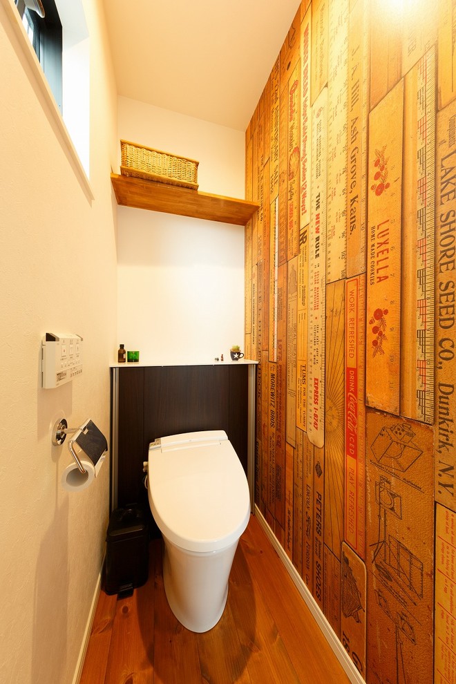 他の地域にあるコンテンポラリースタイルのおしゃれなトイレ・洗面所 (マルチカラーの壁、無垢フローリング、茶色い床) の写真