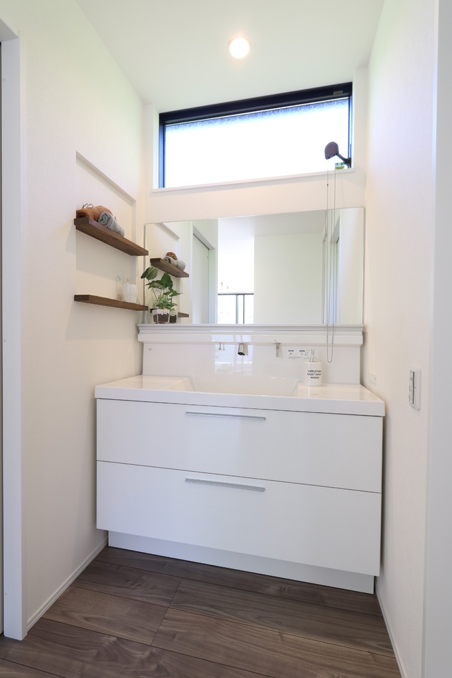 На фото: туалет в стиле модернизм с плоскими фасадами, белыми фасадами, белыми стенами, деревянным полом и серым полом с