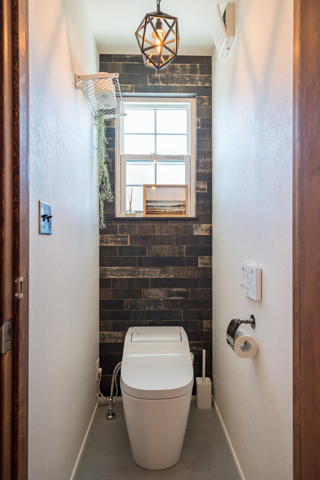 На фото: туалет в стиле кантри с разноцветными стенами, бетонным полом и серым полом