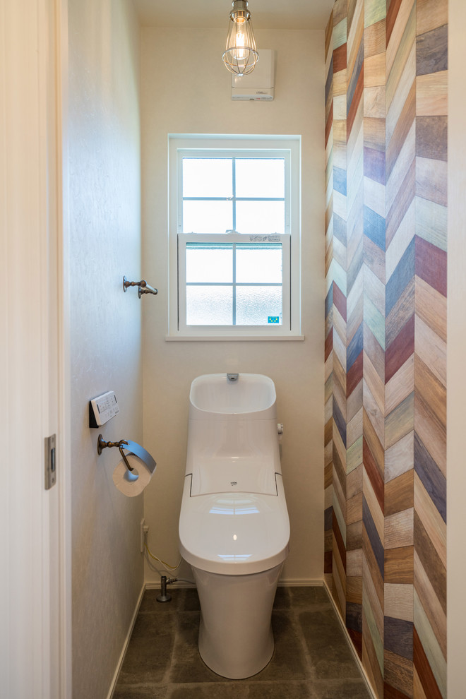 Cette photo montre un WC et toilettes tendance avec un mur multicolore, sol en béton ciré et un sol gris.