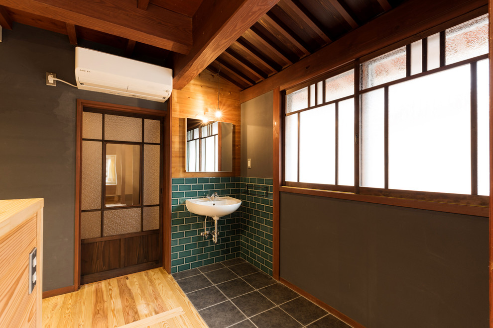 Пример оригинального дизайна: туалет в восточном стиле с керамогранитной плиткой, серыми стенами, полом из керамогранита, подвесной раковиной и черным полом