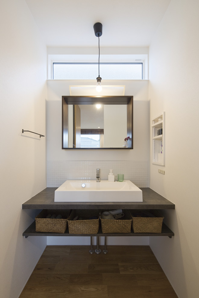 他の地域にあるアジアンスタイルのおしゃれなトイレ・洗面所 (オープンシェルフ、白い壁、ベッセル式洗面器、茶色い床) の写真