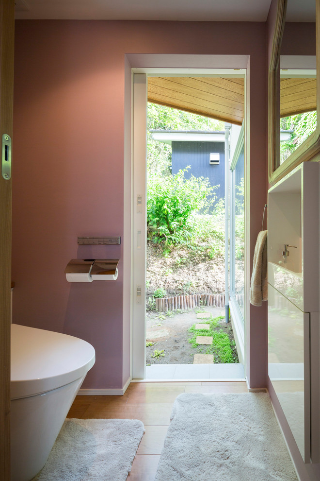 横浜にある北欧スタイルのおしゃれなトイレ・洗面所 (ピンクの壁、無垢フローリング、茶色い床) の写真