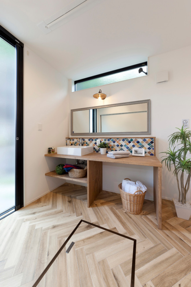 Exemple d'un WC et toilettes avec un carrelage multicolore, mosaïque, un mur blanc, parquet clair, un plan de toilette en bois, un sol beige et un plan de toilette beige.