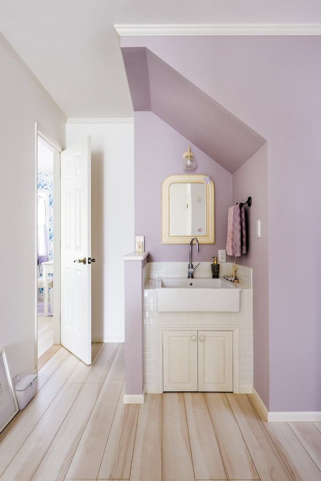 Immagine di un bagno di servizio tradizionale con ante con riquadro incassato, ante bianche, pareti viola, pavimento in legno verniciato e pavimento beige
