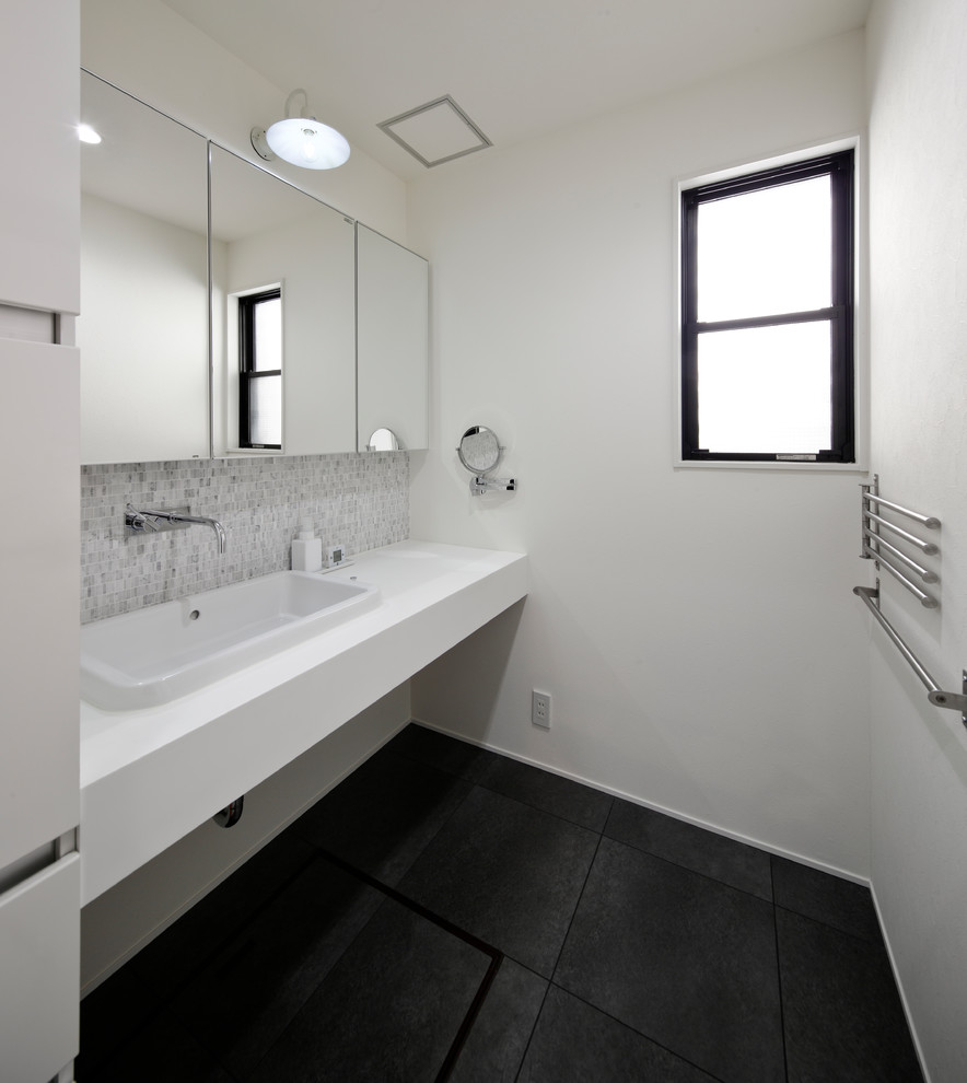 他の地域にあるモダンスタイルのおしゃれなトイレ・洗面所 (白い壁、オーバーカウンターシンク、グレーの床) の写真