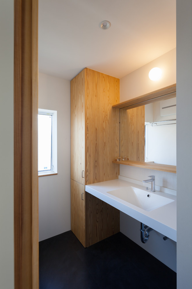 Design ideas for a small contemporary cloakroom in Yokohama with flat-panel cabinets, medium wood cabinets, white tiles, ceramic tiles, white walls, lino flooring, solid surface worktops, black floors and white worktops.