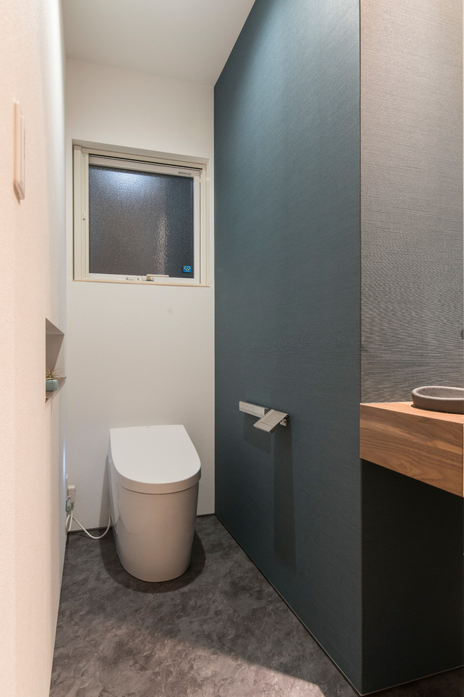 Inspiration för mellanstora moderna toaletter, med öppna hyllor, vita skåp, svarta väggar, ett undermonterad handfat och grönt golv