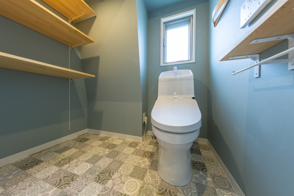 Ispirazione per un bagno di servizio shabby-chic style di medie dimensioni con ante con finitura invecchiata, WC monopezzo, pareti blu, pavimento in legno massello medio e pavimento multicolore