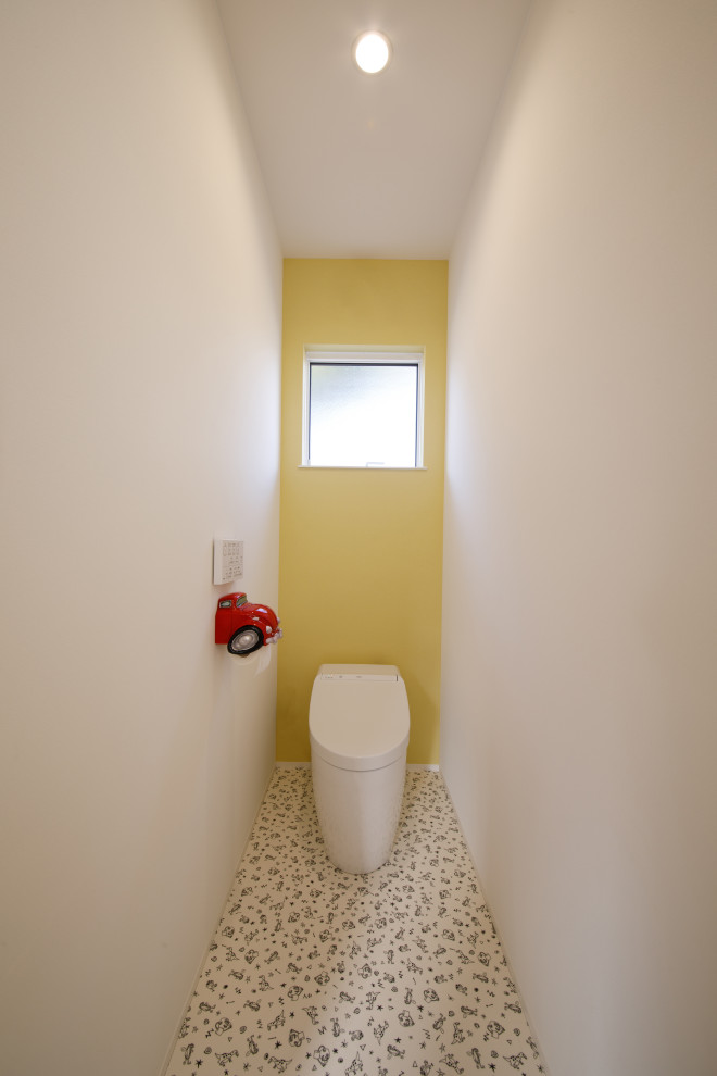 Exemple d'un WC et toilettes scandinave avec WC à poser et un mur jaune.