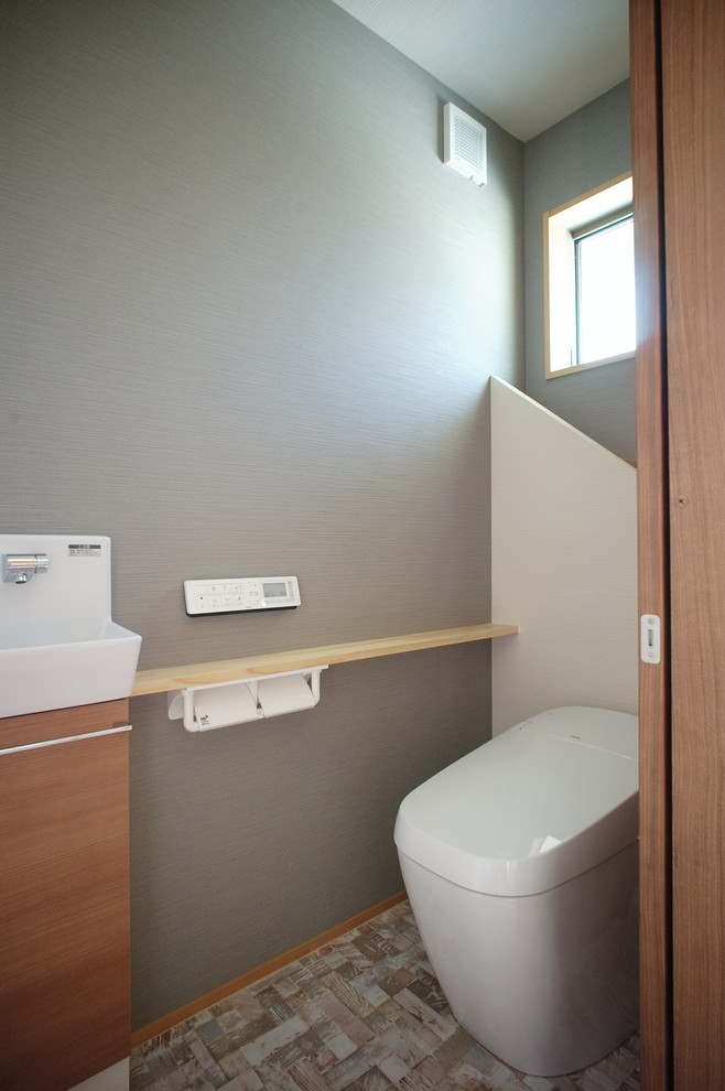 Идея дизайна: туалет в современном стиле с унитазом-моноблоком, серыми стенами, полом из винила и бежевым полом