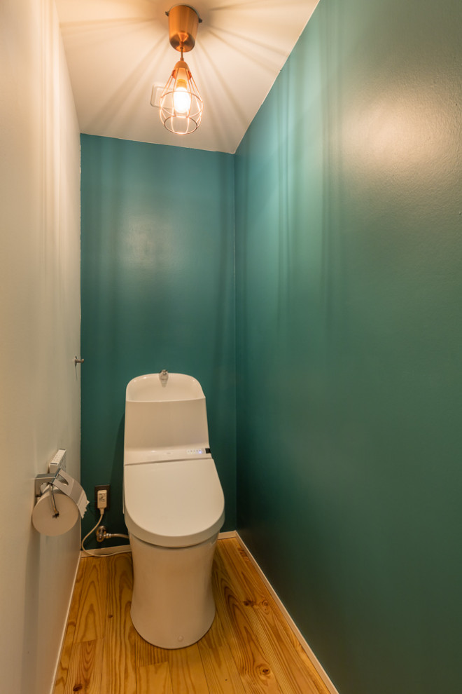 Inspiration för små moderna toaletter, med en toalettstol med hel cisternkåpa, vita väggar, mellanmörkt trägolv, ett fristående handfat och beiget golv