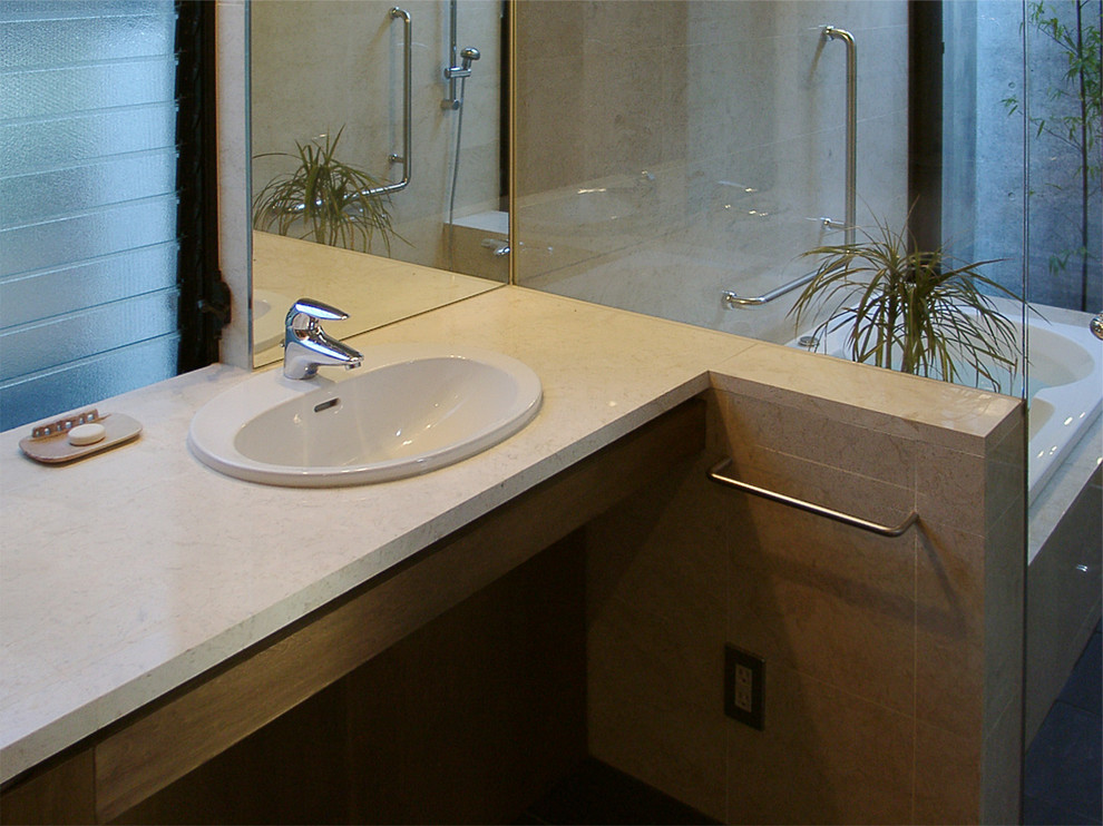 Bild på ett toalett, med öppna hyllor, beige kakel, stenkakel, beige väggar och ett nedsänkt handfat
