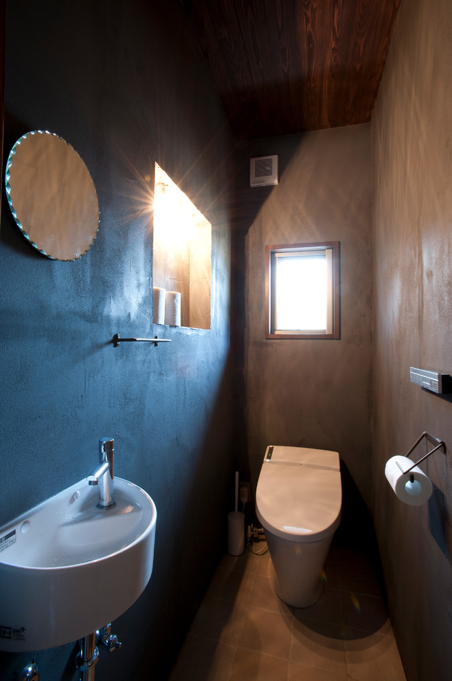 Imagen de aseo asiático con sanitario de una pieza, baldosas y/o azulejos beige, baldosas y/o azulejos de porcelana, paredes negras, suelo de baldosas de cerámica y lavabo suspendido