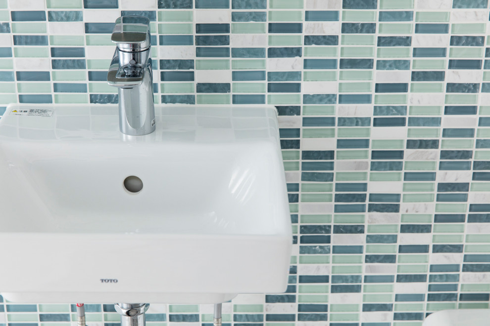 Esempio di un piccolo bagno di servizio moderno con WC monopezzo, piastrelle verdi, piastrelle a mosaico, pareti verdi, pavimento in gres porcellanato, lavabo sospeso e pavimento bianco