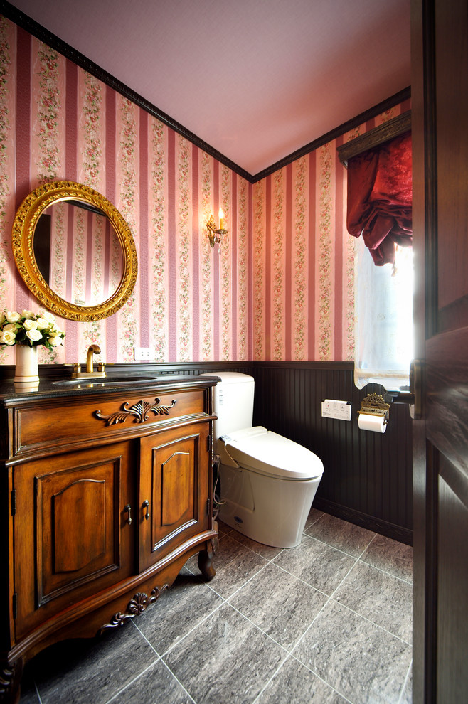 Ispirazione per un bagno di servizio chic con ante con finitura invecchiata, pareti rosa, lavabo da incasso e pavimento grigio