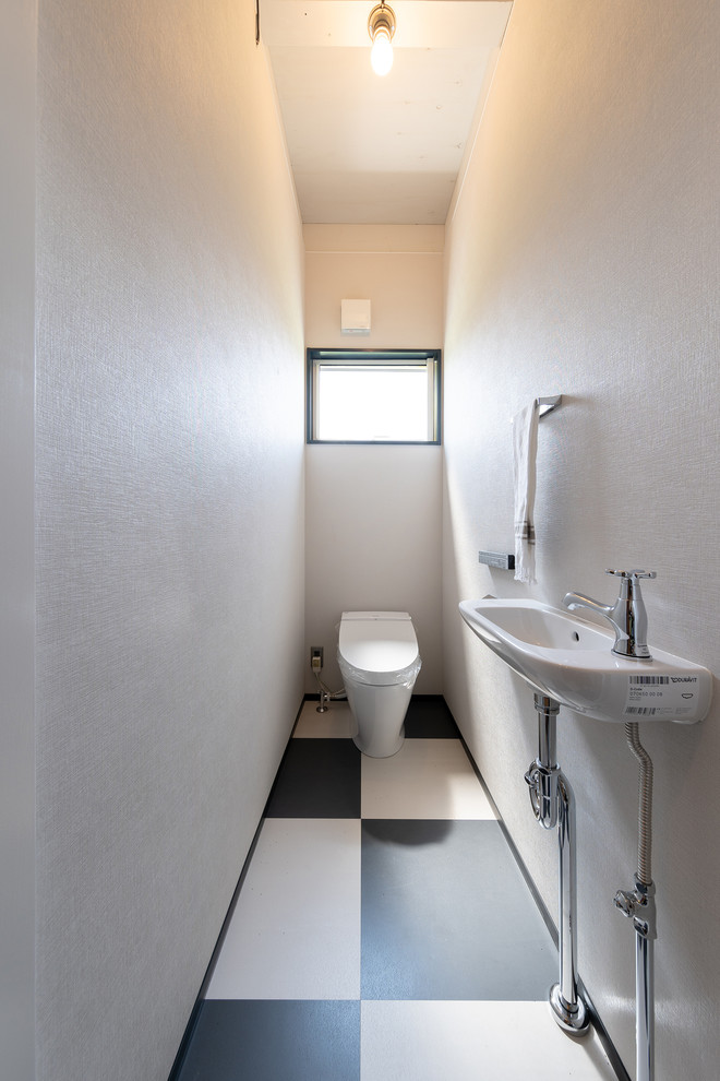 他の地域にあるインダストリアルスタイルのおしゃれなトイレ・洗面所 (白い壁、コンソール型シンク、マルチカラーの床) の写真