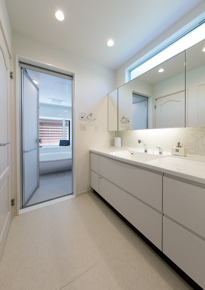 Imagen de aseo moderno con paredes blancas, lavabo integrado y suelo gris