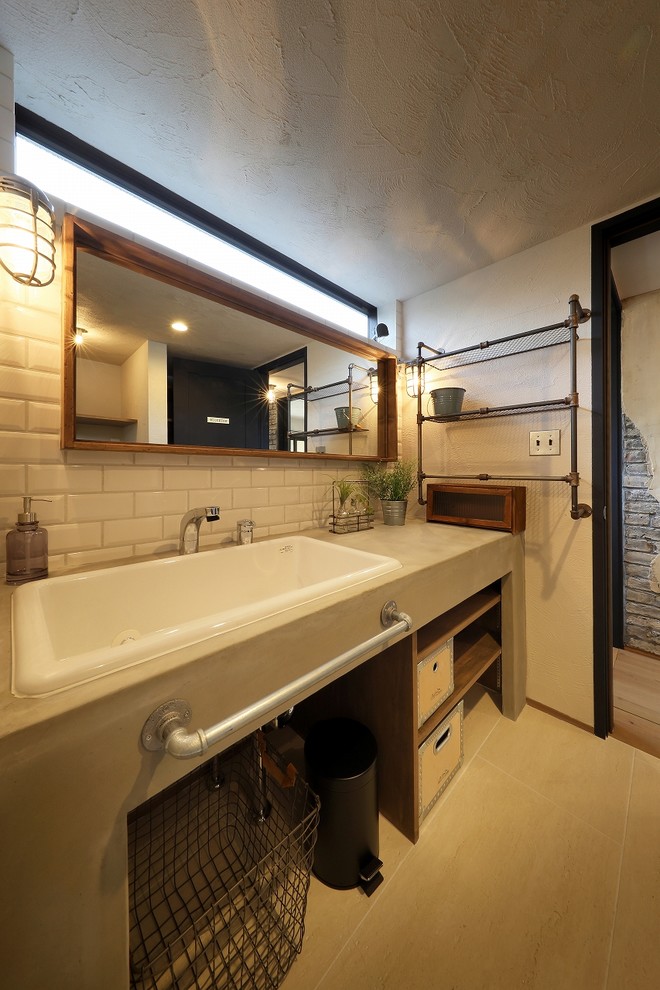 他の地域にあるインダストリアルスタイルのおしゃれなトイレ・洗面所 (オープンシェルフ、白い壁、オーバーカウンターシンク、コンクリートの洗面台、ベージュの床) の写真