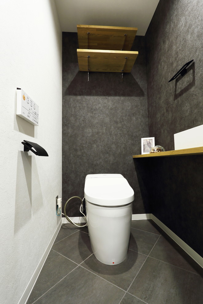 Photo of a medium sized cloakroom in Tokyo with black walls and a vessel sink.