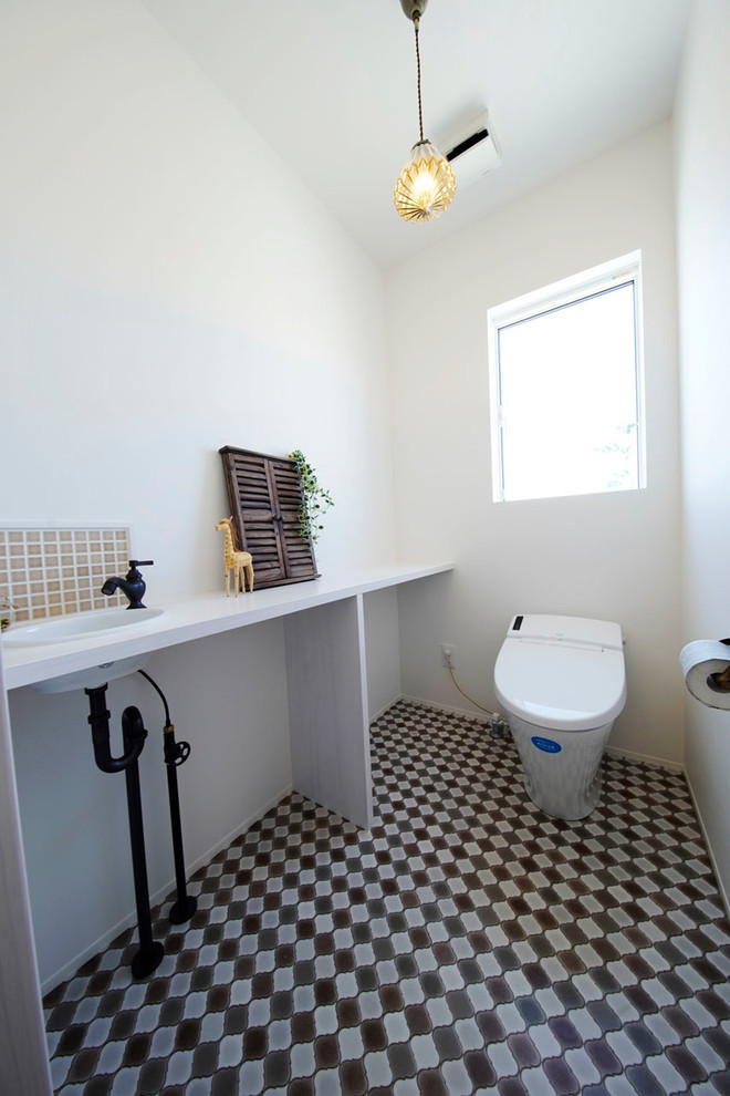 Idee per un bagno di servizio scandinavo con pareti bianche, lavabo da incasso e pavimento multicolore