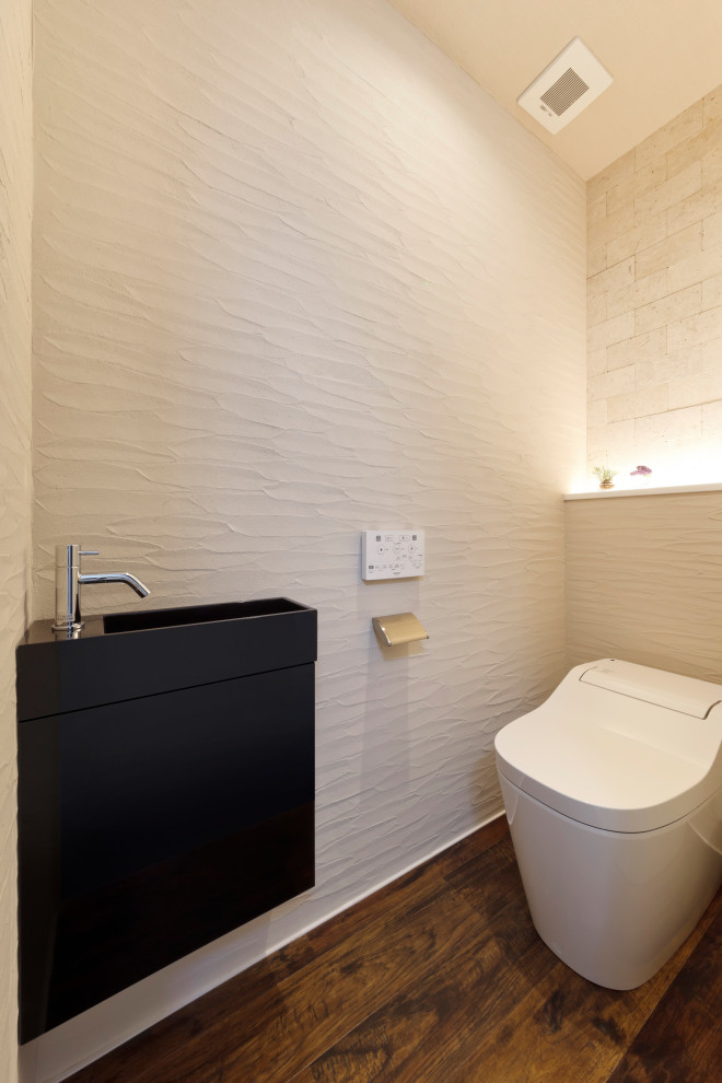 Cette photo montre un WC et toilettes avec des portes de placard noires, WC à poser, un mur blanc, un sol en carrelage imitation parquet, un sol marron, un plafond en papier peint et du lambris de bois.