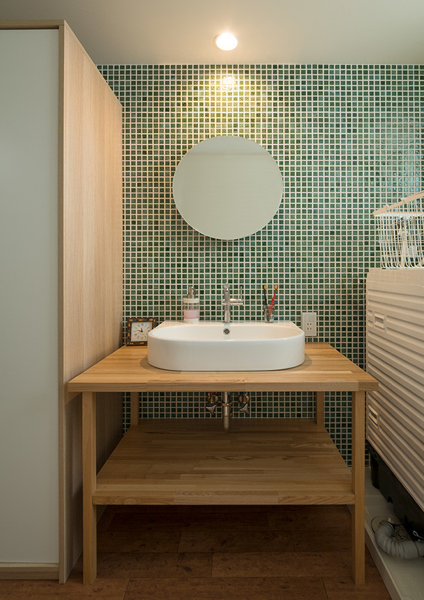 На фото: туалет в современном стиле с открытыми фасадами, зеленой плиткой, настольной раковиной, столешницей из дерева и коричневым полом