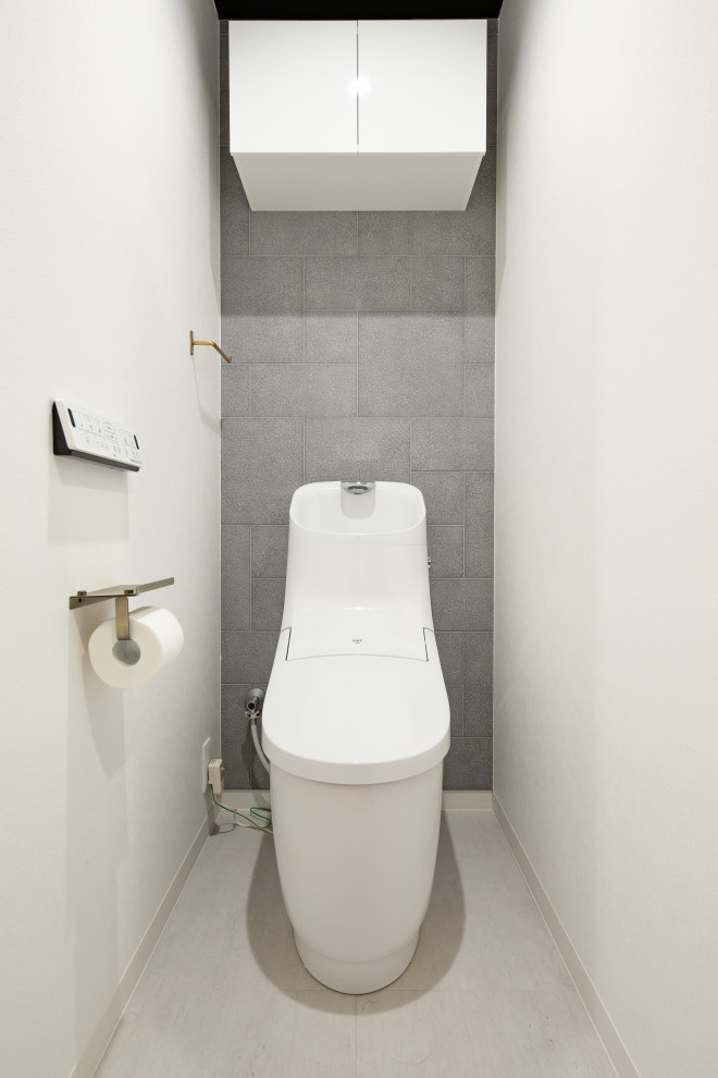 名古屋にある高級な中くらいなインダストリアルスタイルのおしゃれなトイレ・洗面所 (ベージュの壁、クロスの天井、グレーのタイル、磁器タイル、ラミネートの床、グレーの床) の写真