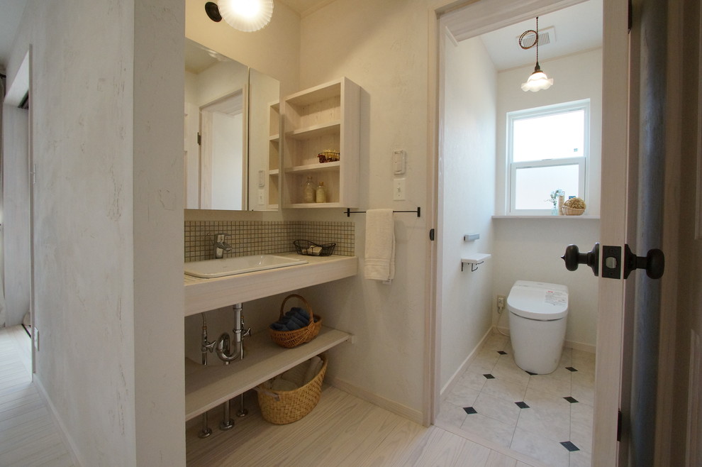 他の地域にある北欧スタイルのおしゃれなトイレ・洗面所 (オープンシェルフ、白い壁、オーバーカウンターシンク、白い床) の写真