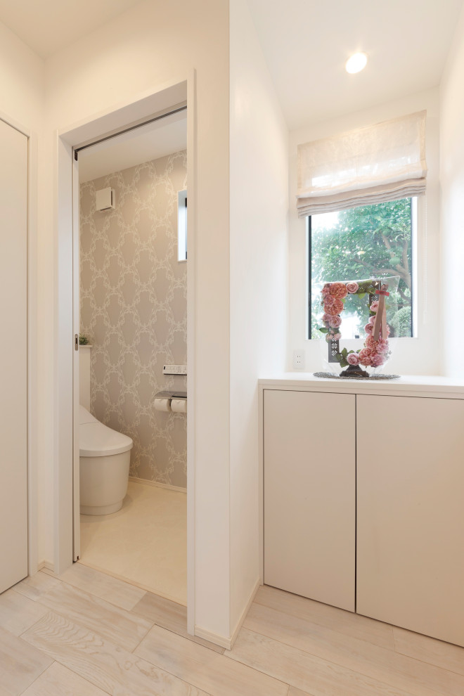 Gästetoilette mit Toilette mit Aufsatzspülkasten, hellem Holzboden, weißem Boden, Holzdielendecke und Holzdielenwänden in Sonstige